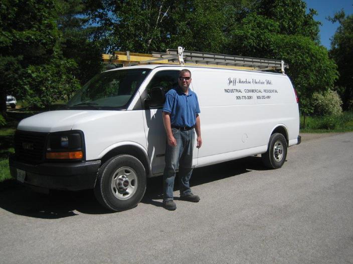 Jay Mackie beside the company van