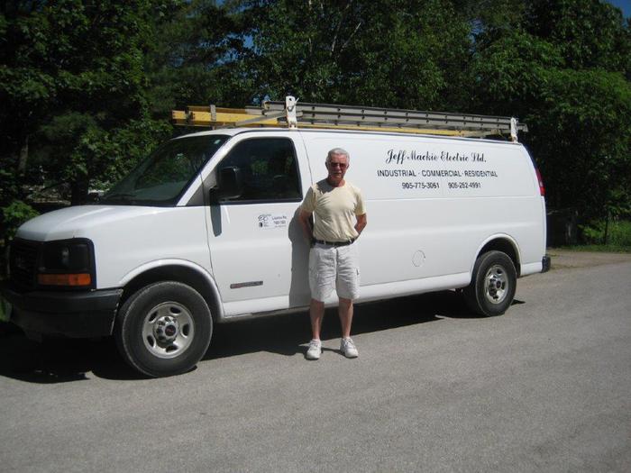 Jeff Mackie beside the company van